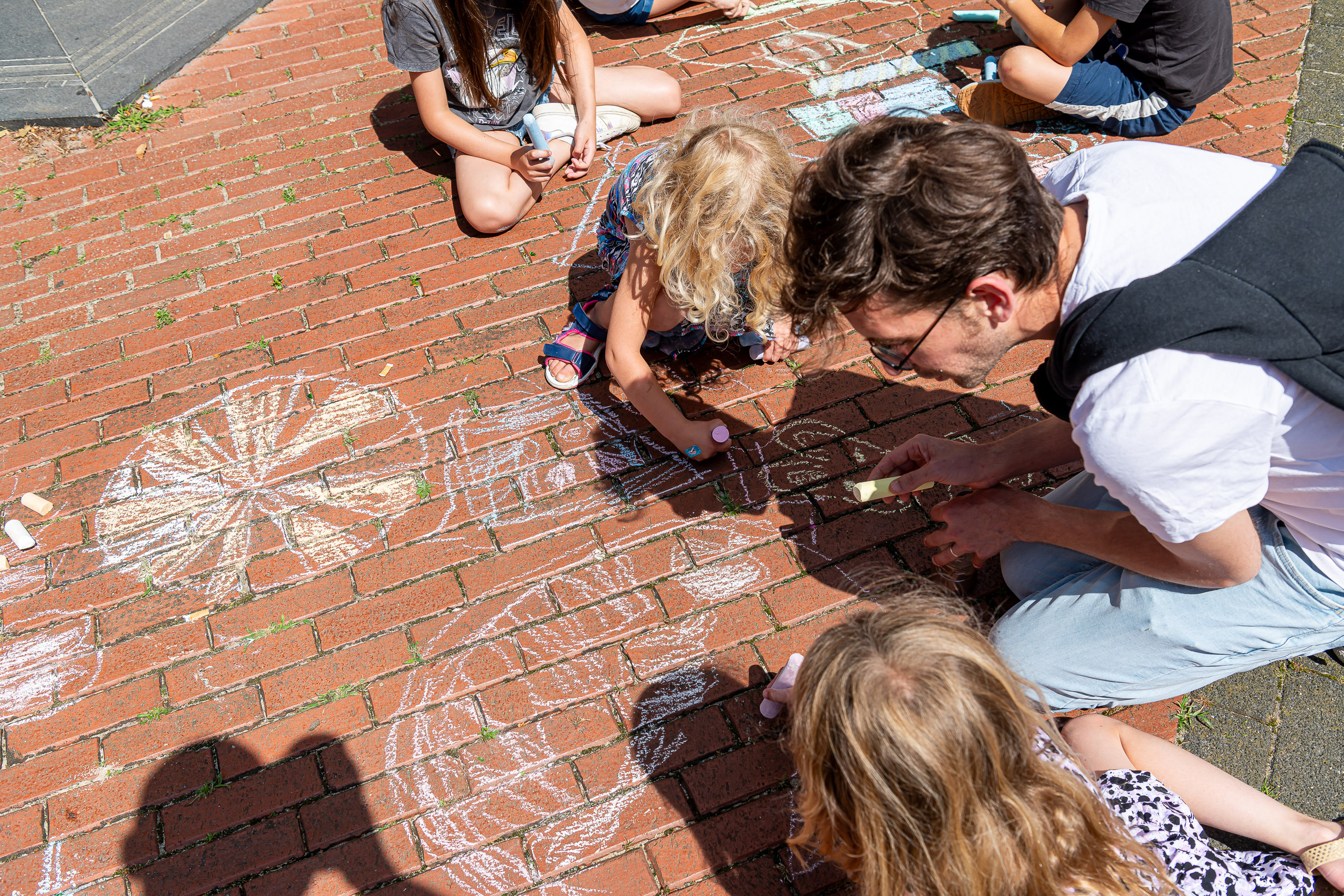 Spelende kinderen met stoepkrijt tijdens de Zomer Doe-Week